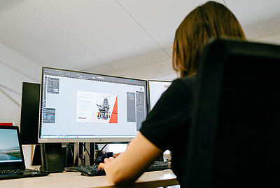 eine Frau sitzt an einem Computer und arbeitet