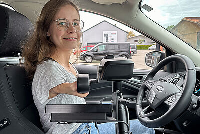 Woman without arms controlling a car with joystick steering – customized vehicle conversion by PARAVAN enables independent driving.