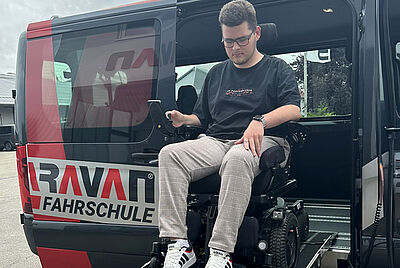 Rollstuhlfahrer fährt über eine Rampe in ein Fahrzeug der PARAVAN Fahrschule für Menschen mit Behinderung.
