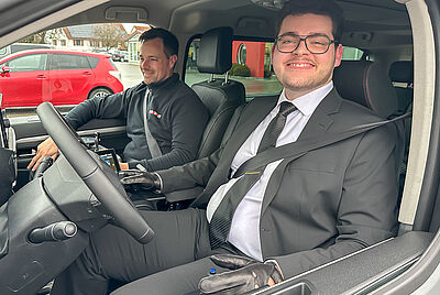 Junger Mann mit Behinderung sitzt am Steuer eines barrierefrei umgebauten Autos mit PARAVAN Fahrhilfen.