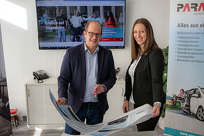 Zwei Menschen besprechen eine ausgedruckte Anzeige 