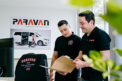 zwei Männer schauen sich eine Broschüre an