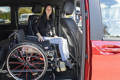 Rollstuhlfahrerin fährt über eine Rampe in ein barrierefrei umgebautes Fahrzeug für Menschen mit Tetraplegie.