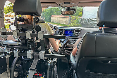 Ein Blick von der Rücksitzbank nach vorne auf die Fahrerseite mit Jana im Rollstuhl, gesichert durch das Paravan-Rückhaltesystem.