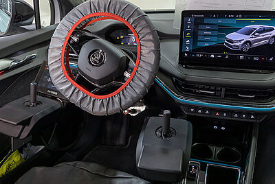 Der Vorderraum eines Autos, ausgestattet zusätzlich zum Lenkrad mit zwei Joystick links und rechts daneben.