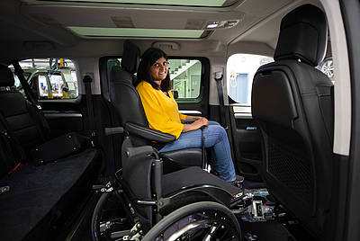 Kundin Anita sitzt stolz in Ihrem behindertengerecht umgebauten Fahrzeug Auto von Paravan