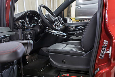 Behindertengerechter Fahrzeugumbau mit angepasstem Fahrersitz und Handbedienung für Autofahren mit Tetraplegie.