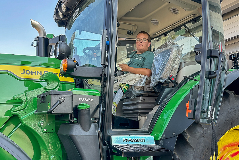Junger Mann im Cockpit eines von PARAVAN individuell angepassten John Deere Traktors.