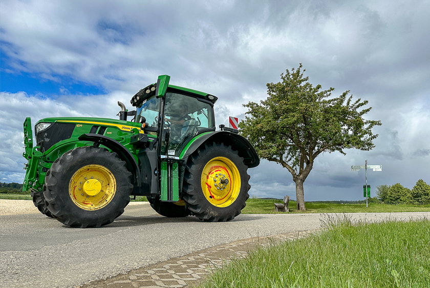 Grüner John Deere Traktor mit individuellem PARAVAN Umbau auf einer Landstraße.