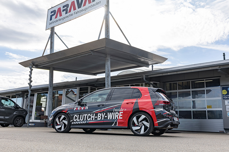 Roter VW Golf GTI mit PARAVAN Clutch-by-Wire im Außengelände der REHACARE 2026 in Düsseldorf