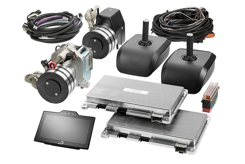 Alle Komponenten von Paravan Space Drive. Links hinten Kabelsatz und zwei Aktuatoren, recht hinten ein weiterer Kabelsatz sowie zwei Joysticks, vorne rechts zwei ECU Steuergeräte Space Drive und vorne links das Touch Display.