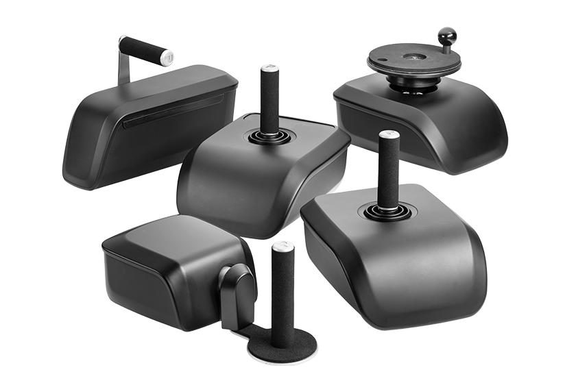 Fünf verschiedene schwarze Joysticks die sich unterschiedlich bewegen lassen. Hinten links Gas- Bremsschieber, rechts hinten Minilenkrad, Mitte 2-wege-Joystick, vorne links Rotationslenker und vorne rechts 4-Wege-Joystick.