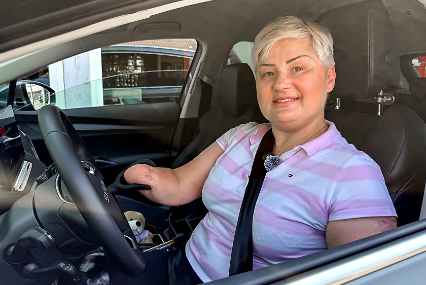 PARAVAN Mobilitätsberatung – Isabella Pietrazak sitzt lächelnd am Steuer ihres Fahrzeugs