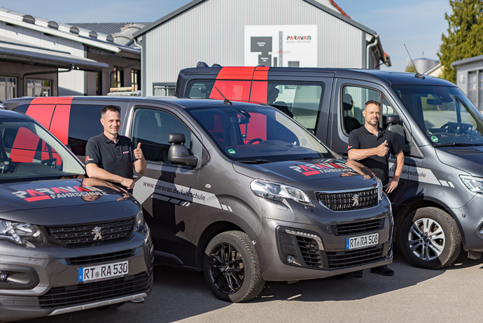 Unsere Paravan Fahrlehrer stehen vor ihrer Fahrzeugflotte